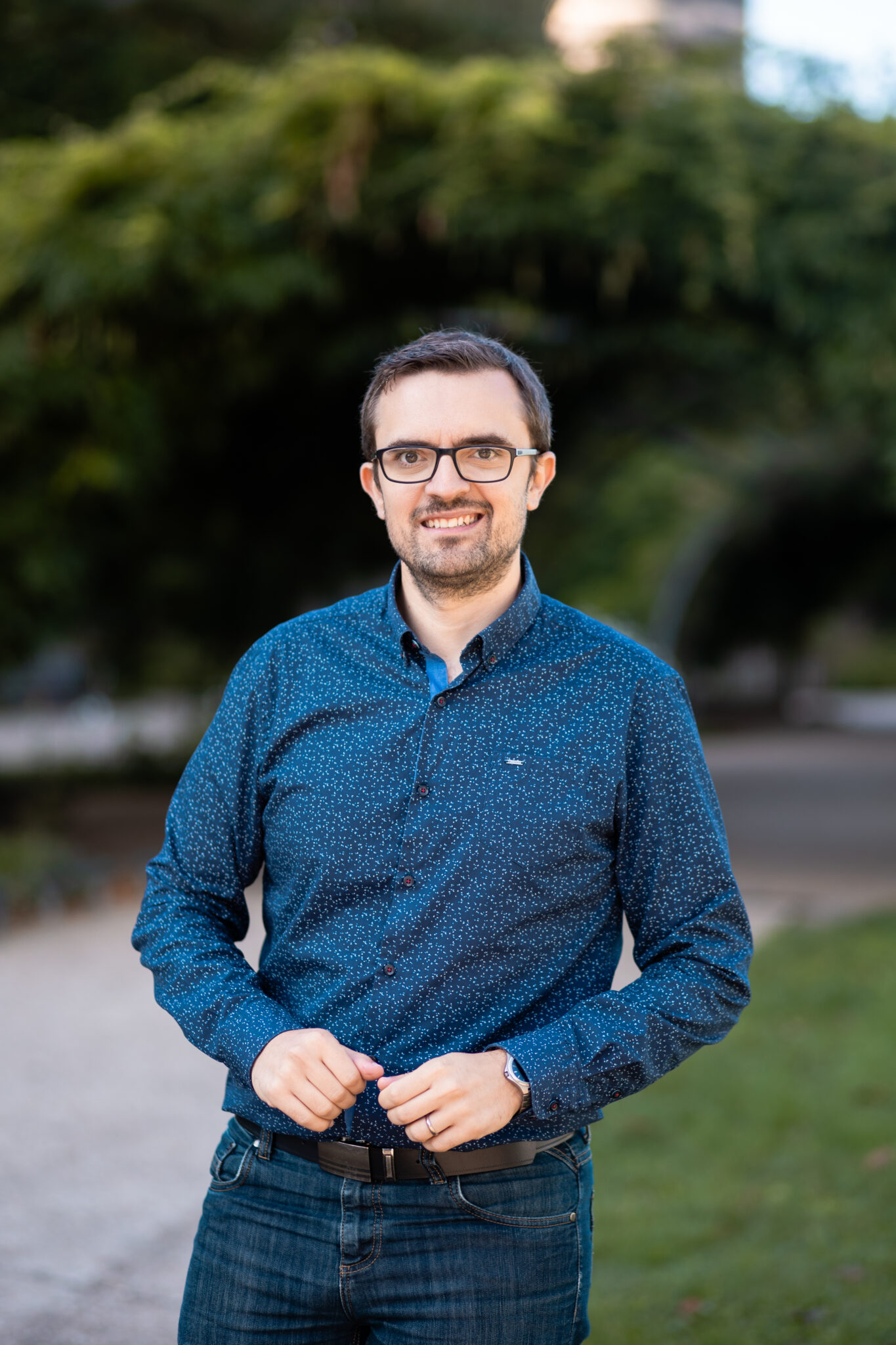 Gaëtan souriant est positionné devant des arbres et la tour du Château d'Angers